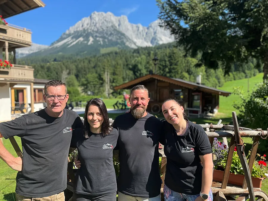 Das Team vom Landhaus Wildschwendt vor dem Haus, im Hintergrund der Wilde Kaiser.