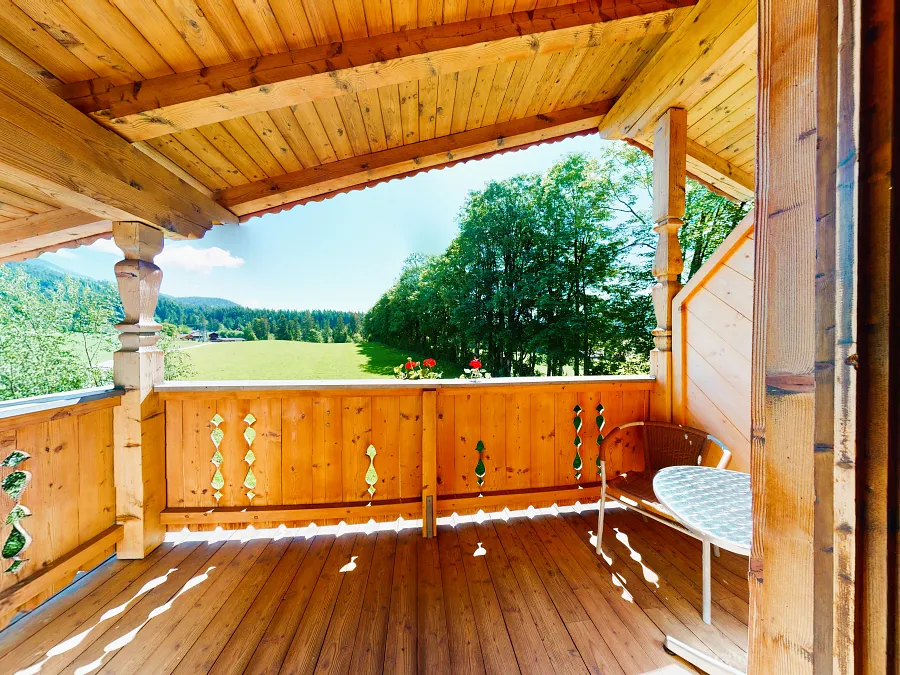 Ost-Balkon des Einzelzimmers mit Tisch und Blick auf Wiesen und Wälder